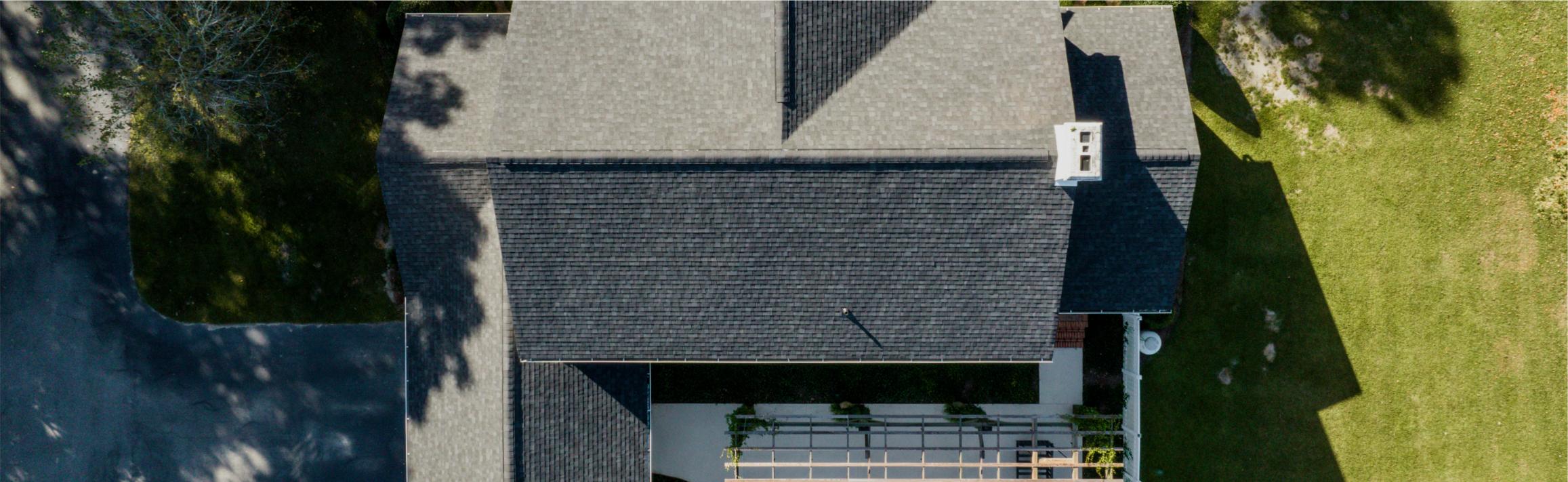 Service Areas Page Hero Image | Aerial View of Home With Architectural Asphalt Shingles | Onyx Black | Evans County Residental Roofers | Residential Roofing